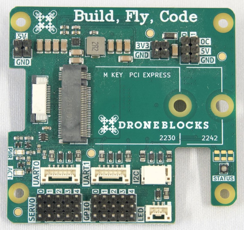 Plan view of the DroneBlocks Pi HAT. Silkscreen labels mark, clockwise from the left edge, the PCIe flat-cable connector, the M.2 M-key slot, the 5 V, 3V3 and actuator power headers, the status LED, the I2C and LED connectors, and the UART0, UART1, servo and GPIO headers along the bottom.